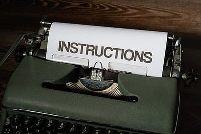 A classic typewriter with a piece of paper and the word 'instructions' typed on it