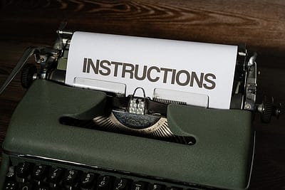 An old typewriter showing the word "instructions" on the piece of paper
