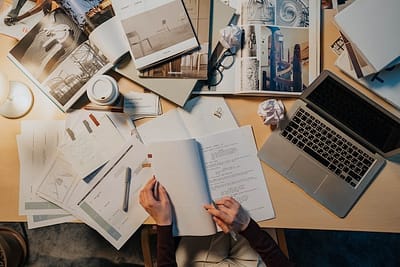 An image showing a desk with numerous paperwork
