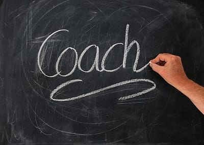 The word "coach" written on a blackboard